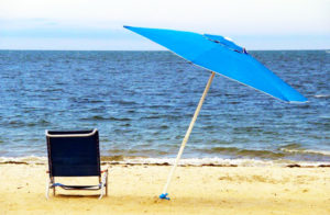 beach chair and umbrella in the sand